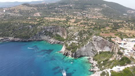 Luftdrohnenvideo-Der-Ikonischen-Küste-In-Der-Nähe-Der-Blauen-Höhlen-Auf-Der-Insel-Zakynthos-Mit-Tiefem-Saphirfelsenmeer-Und-Kleinen-Booten,-Die-Durch-Das-Kristallklare-Wasser-In-Griechenland-Navigieren