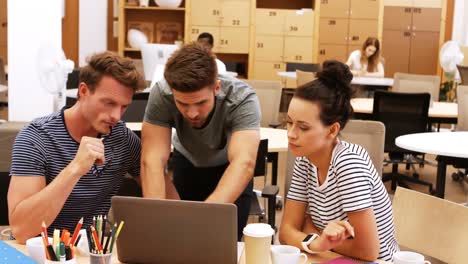 ejecutivos de negocios masculinos y femeninos discutiendo sobre computadora portátil en su escritorio