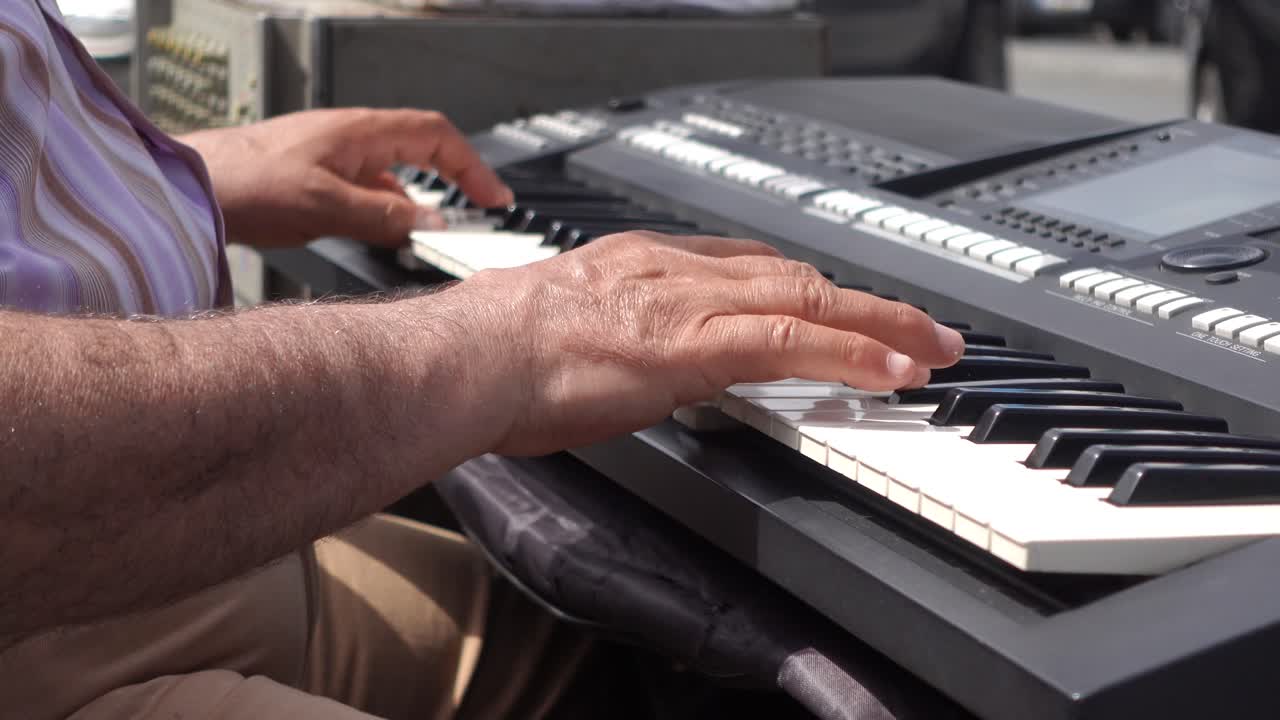 남자가 야외에서 디지털 키보드를 연주하고 있습니다.