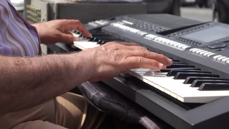hombre tocando un teclado digital al aire libre