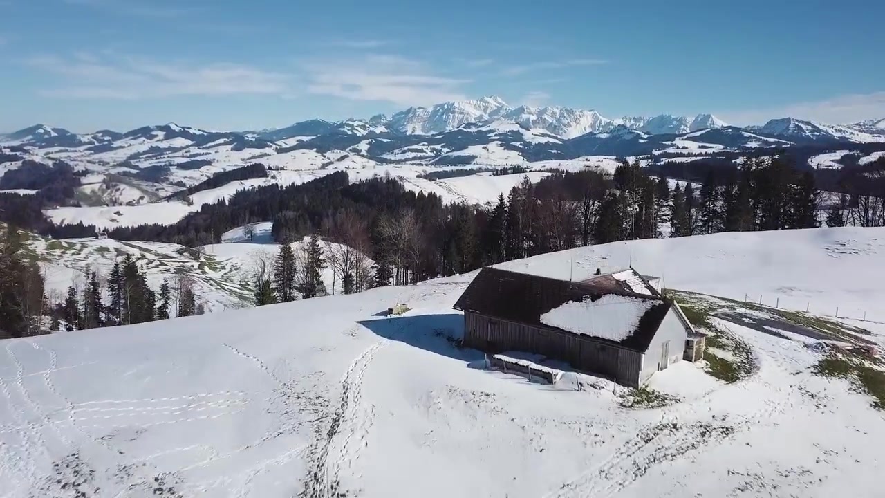 Ripresa veloce con drone sopra una collina e una casa nelle Alpi svizzere.