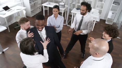 laughing businessman playing trust game with colleagues