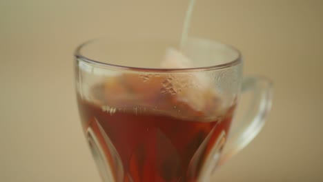 close-up of a steaming cup of tea with a tea bag steeping in it