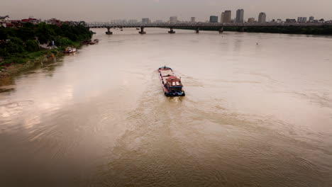 cargo vessel transports sand down red river through hanoi, aerial view