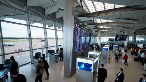airport terminal with flight information display and passengers