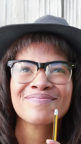 mujer hipster sonriente con lápiz