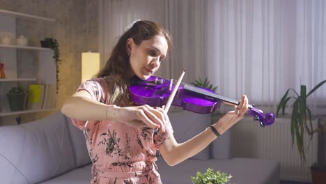 Young-girl-plays-the-violin-in-the-living-room.