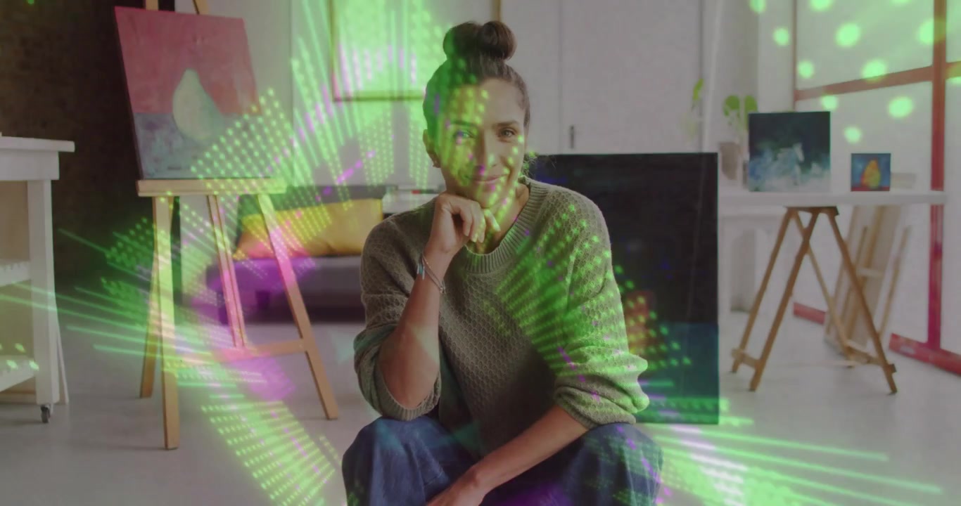 Video verticale: Donna seduta con top in maglia che reagisce a una sovrapposizione verde-rosa che scorre su cavalletti da studio.