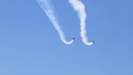 aviones realizando acrobacias con rastros de humo en el cielo