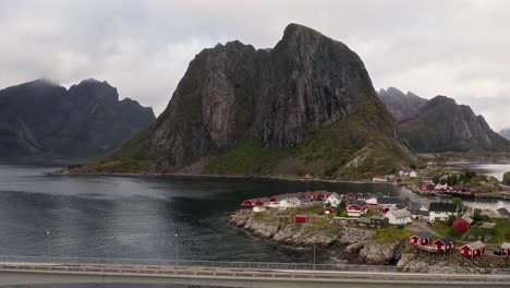 Aerial-view-pushing-toward-Hamnøy-village,-full-with-red-rorbu-houses,-moody-atmosphere,-Reine,-Lofoten-Islands,-Norway