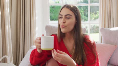 Video-Von-Glücklichen-Kaukasischen-Frauen,-Die-Auf-Dem-Sofa-Sitzen-Und-Kaffee-Trinken