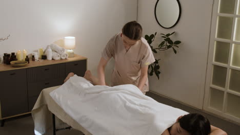 woman receiving a professional leg massage at a spa