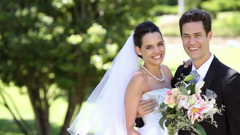 Happy-newlyweds-standing-in-the-park