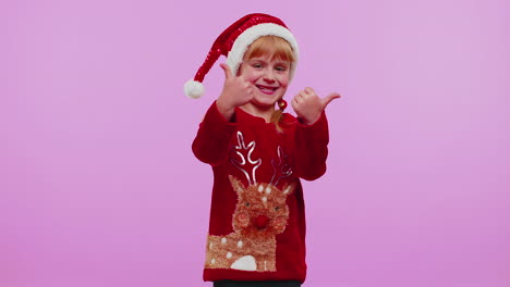 Funny-girl-in-red-New-Year-sweater-raises-thumbs-up-agrees-something-good,-like,-violet-background