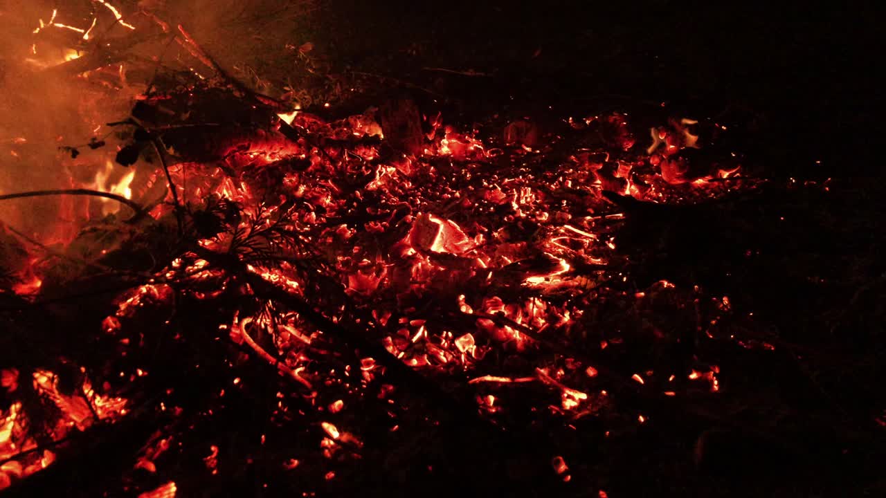 Red hot burning embers and charcoal on bonfire floor