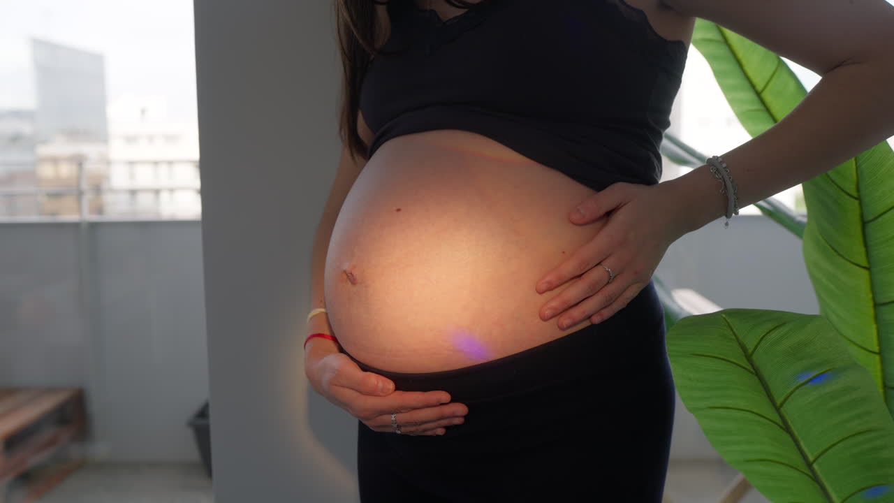 Pregnant Woman Gently Caressing Her Baby Bump with Love