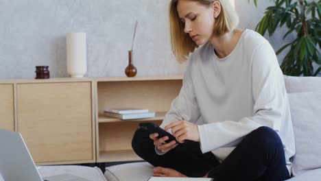 mujer usando un teléfono inteligente en casa