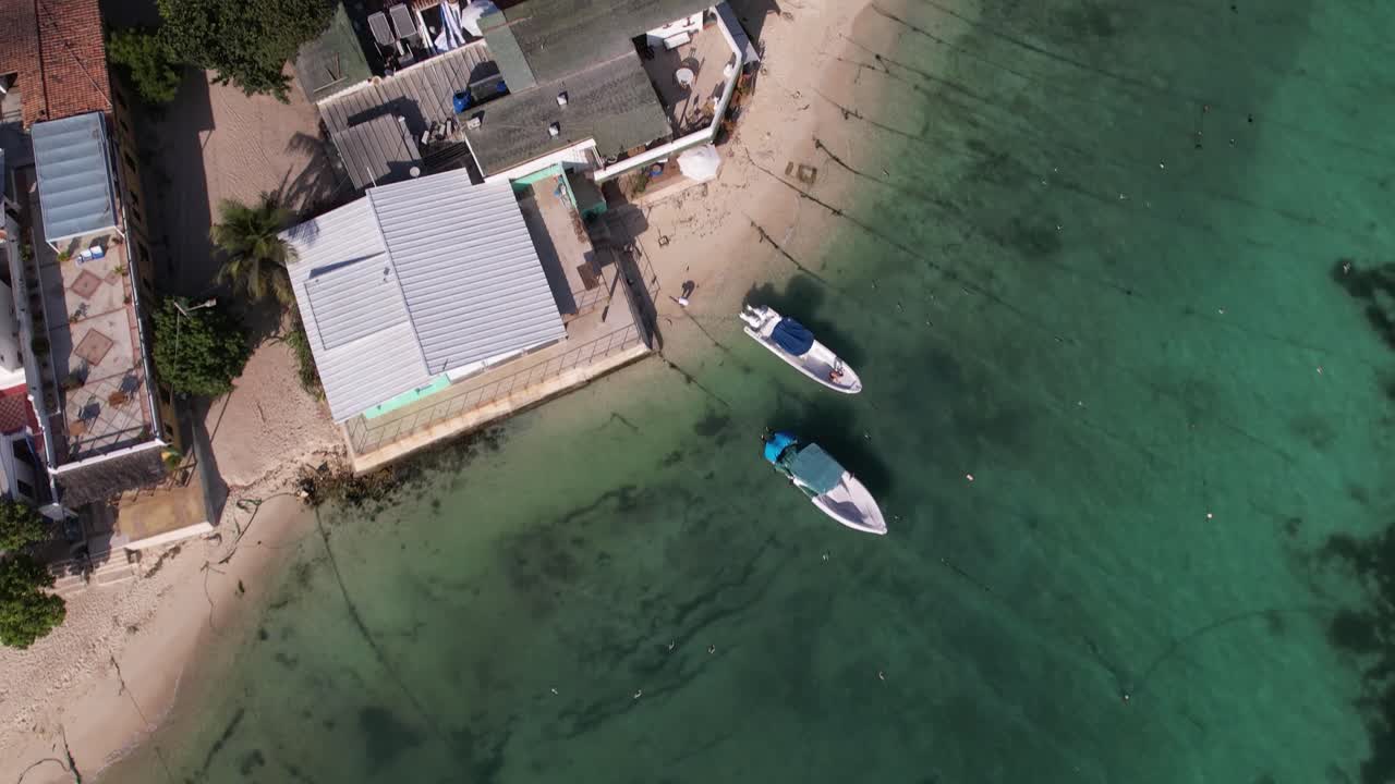 Aerial top down view of coastal fishing village with vessel, pier, harbour and airport, Caribbean island