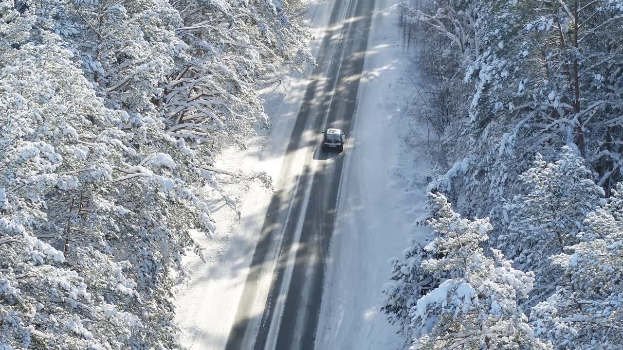 Road in the snowy forest. Drone aerial view. Winter landscape in Lithuania