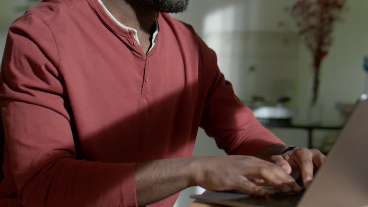 African American Man Using Laptop in Evening at Home