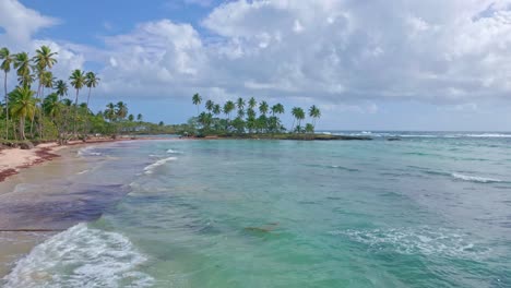 Drone-flying-over-turquoise-waters-of-Los-Coquitos-beach,-Cabrera-in-Dominican-Republic