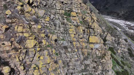 Langsam-Bewegte-Enthüllung-Hinter-Gelben,-Mit-Pilzen-Bedeckten-Felsen-Zur-California-Highway-38-Valley-Road,-Die-Zu-Waldfällen-Führt,-Mit-Dramatischen-Schatten-Von-Bergen-Und-Vorbeifahrenden-Autos,-Luftenthüllung-60fps