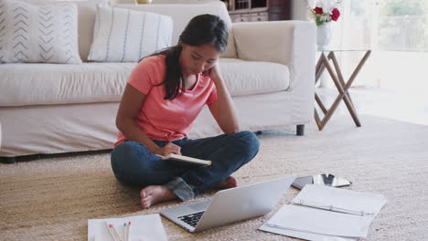 Teenager-Afroamerikanerin-Sitzt-Mit-Laptop-Auf-Dem-Boden-Im-Wohnzimmer-Und-Macht-Ihre-Hausaufgaben,-Nahaufnahme
