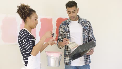 young couple trying out different shades of paint