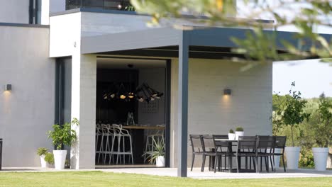 slow revealing shot of a modern white villa with garden seating under a canopy