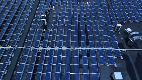 the aerial shot of solar panels on the roof of industrial building