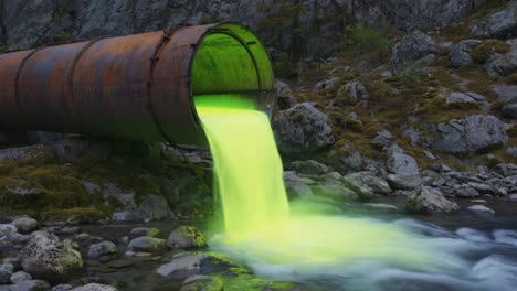 toxic green liquid discharged from rusty pipe into stream