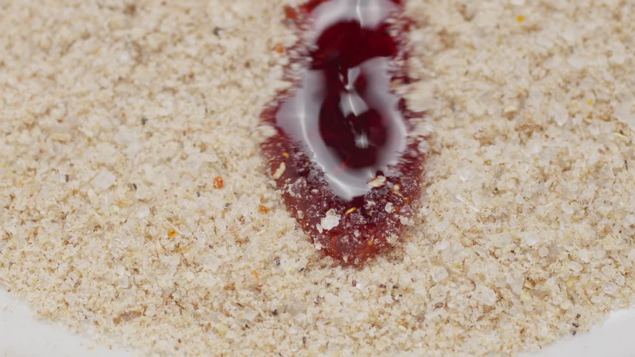 Chili Oil Dripping Onto Coarse Seasoning Powder. closeup shot