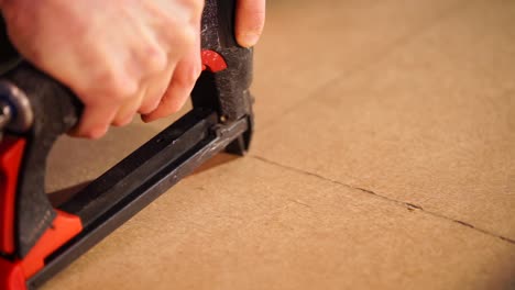 person using a nail gun to assemble wooden panels