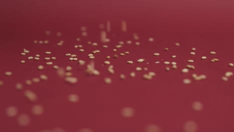 Sesame-seeds-falling-on-red-background