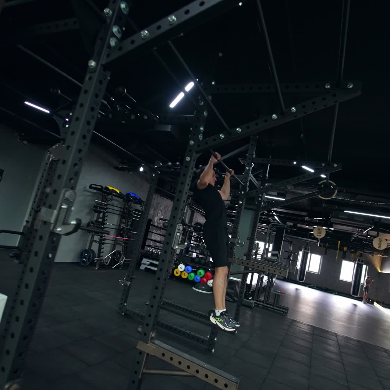 Handsome young sportsman comes up to a horizontal bar in the sport gym ...