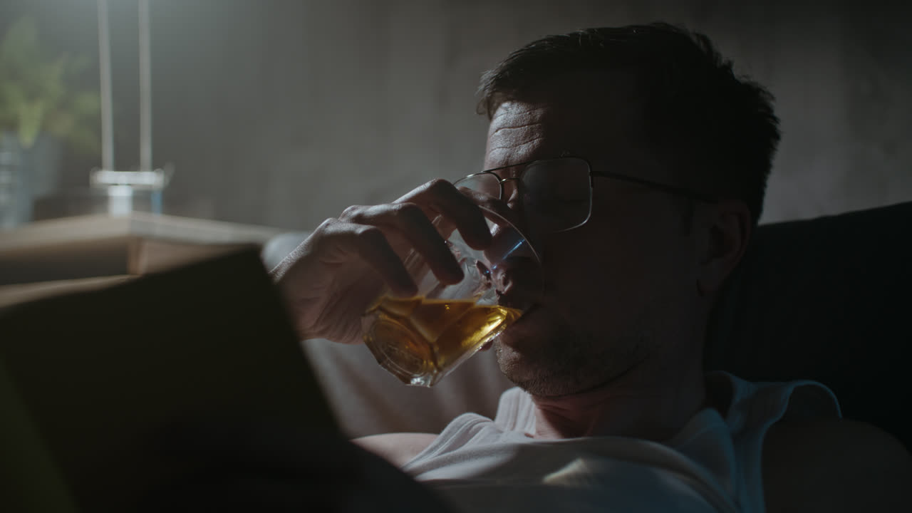 一个悲伤的男人晚上穿着内衣看书。