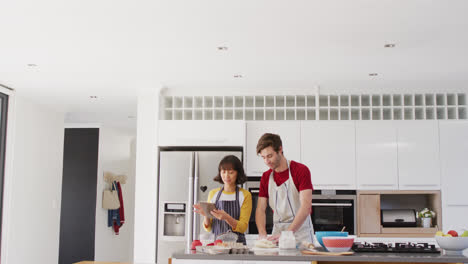 video of happy diverse couple baking together in kitchen