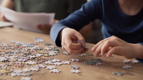 video of son solving jigsaw puzzle during father working at home