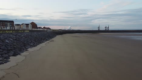 Drohnenaufnahme-Bei-Sonnenaufgang-Am-Strand-Von-Aberavon-Mit-Stahlwerken-Und-Strandpromenade