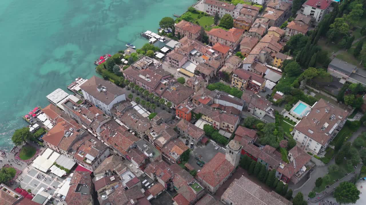 Tight drone angle over rooftops near Scaliger Castle with textured terracotta tiles