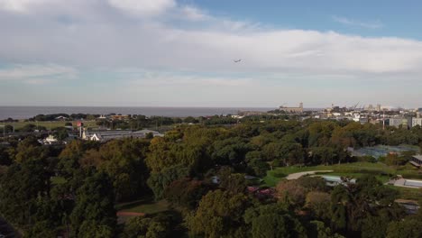 drone volando sobre el parque de palermo con avión despegando en segundo plano