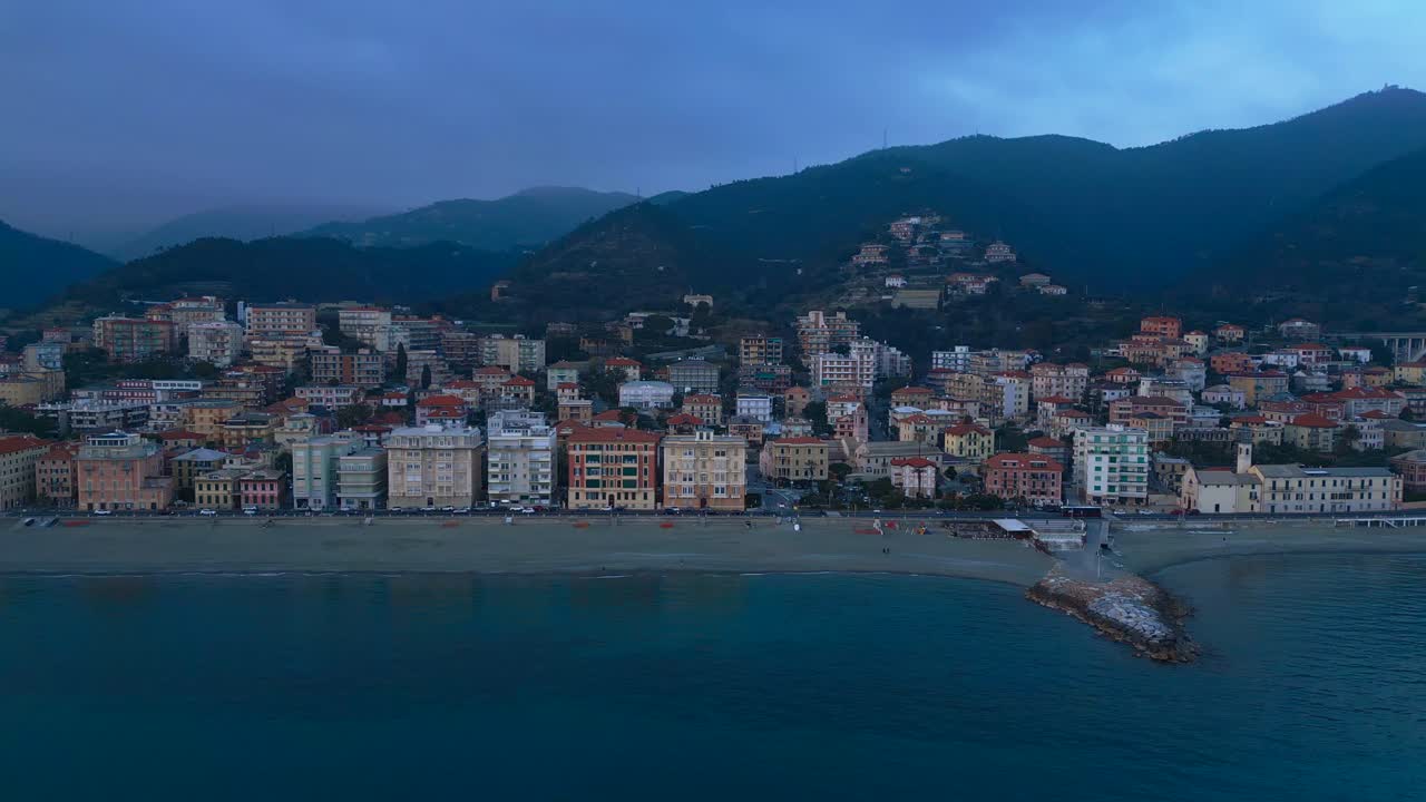 Aerial shot rising above the coastline with picturesque houses of the Ligurian town, Varazze, Italy