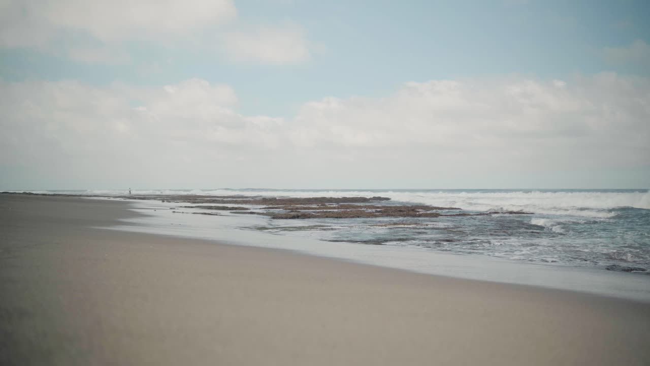 la playa de la unión con vista de ángulo bajo de las olas del océano rodando sobre la arena en las filipinas