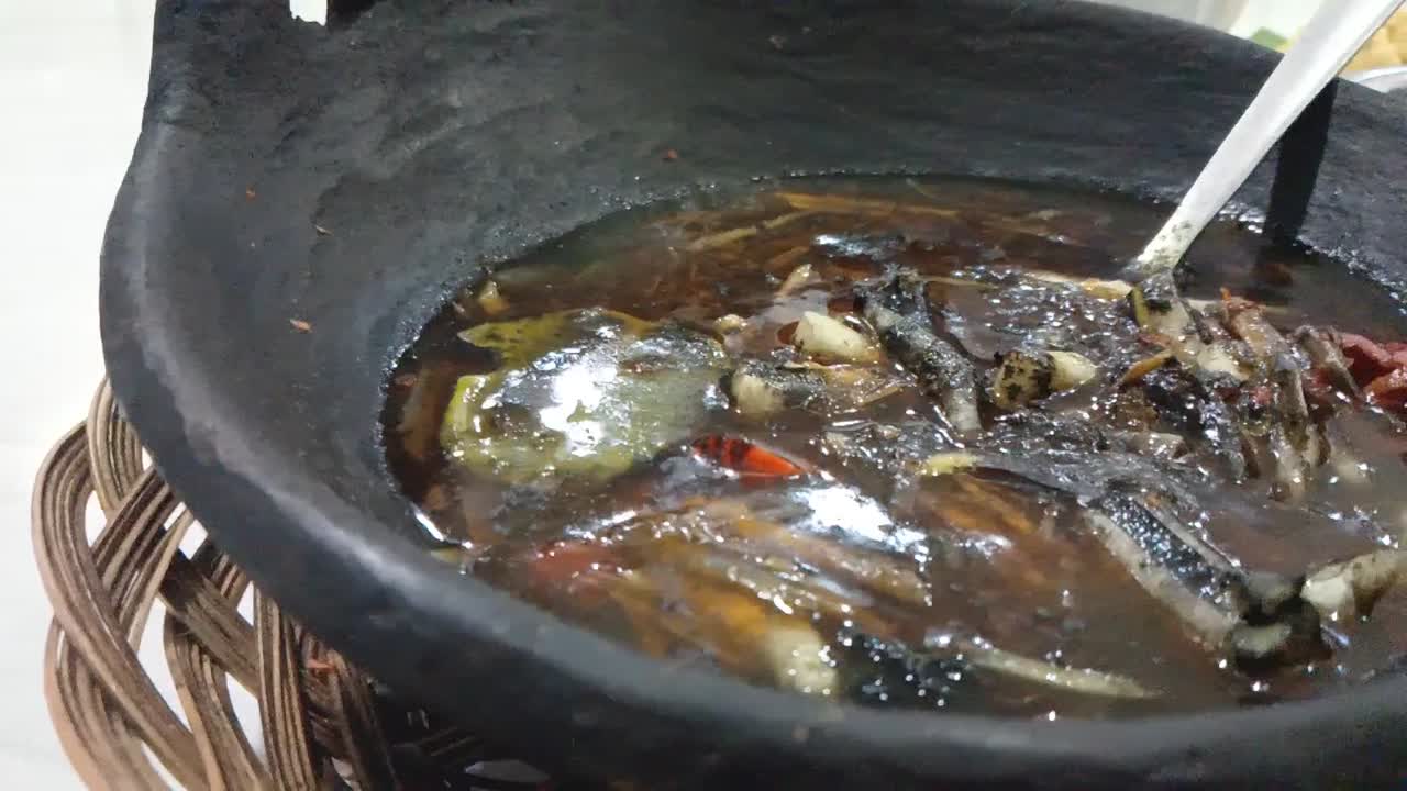 Close-up of a Dark, Spicy Seafood Dish in a Clay Pot