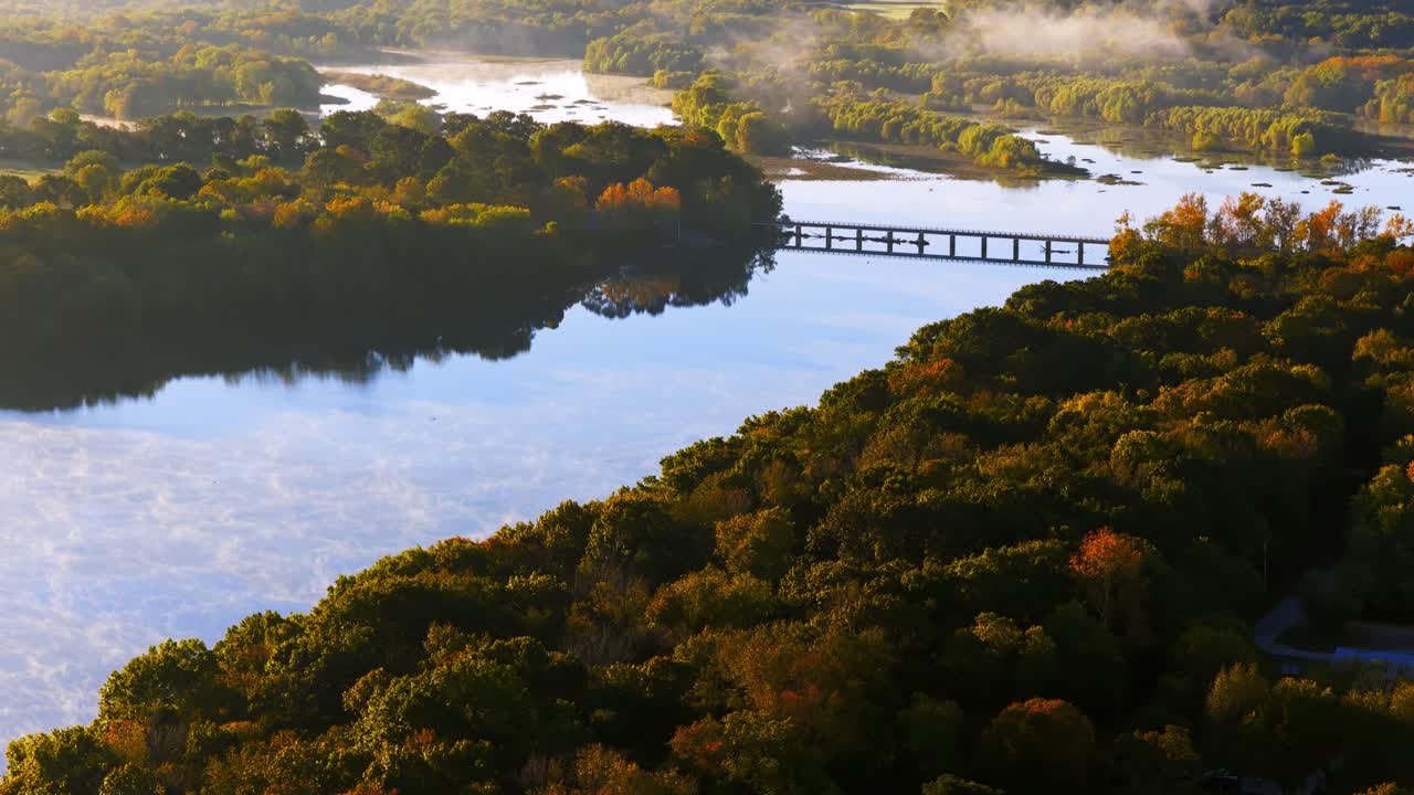 セコイア湖にかかる橋、秋のオレンジと緑の森、穏やかな水面に映る景色、空には霧が立ち込め、ワイマン・アーカンソー（米国）を空撮で引いて撮影。