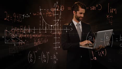 man on laptop smilling over mathematical equations.