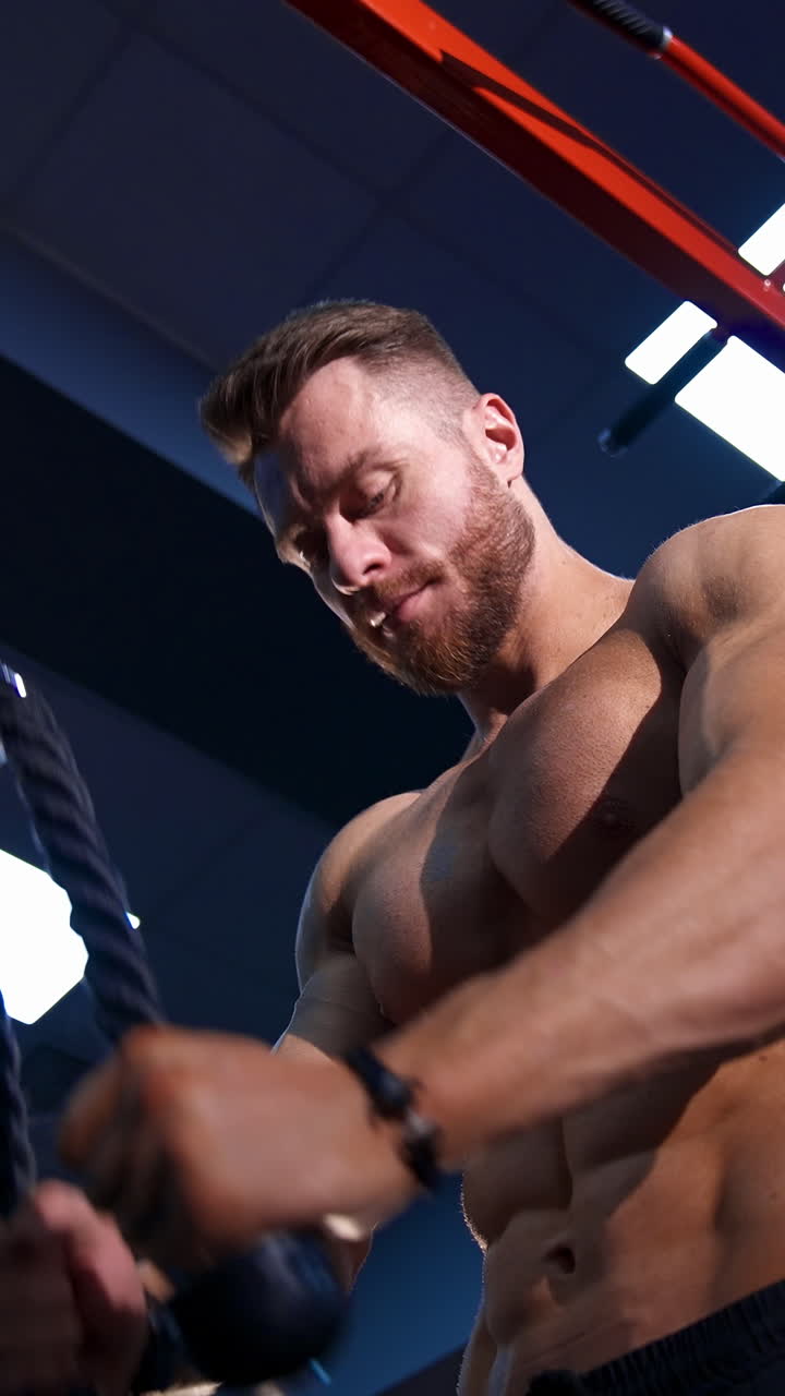 Bodybuilder working out in gym. Muscular bodybuilder guy doing exercises in gym. Vertical video