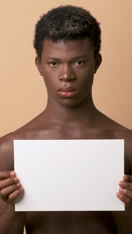 serious african transgender person holding a blank poster