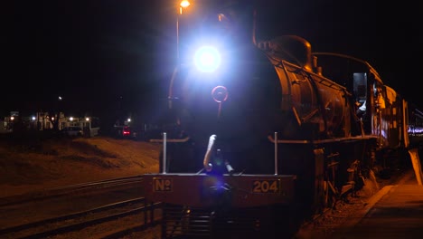 An-old-steam-train-pulls-into-a-station-at-night-in-Zimbawbwe-Africa-with-wealthy-tourists-on-board