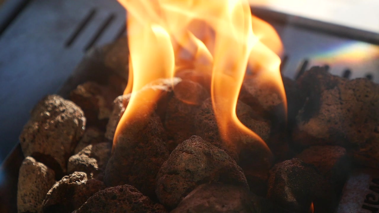 Close-up of Warm Flames Burning on Lava Rocks in a Fire Pit